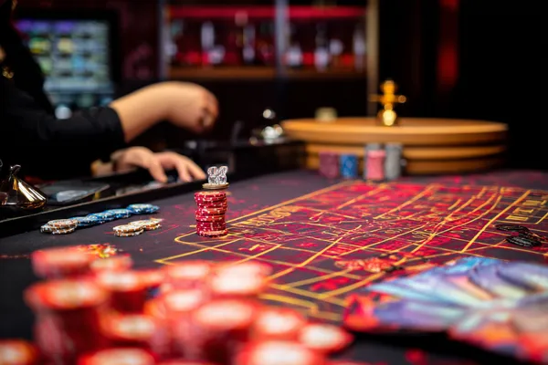A glowing roulette wheel with cascading chips, symbolizing the engaging live and instant-win games available on 588WIM.